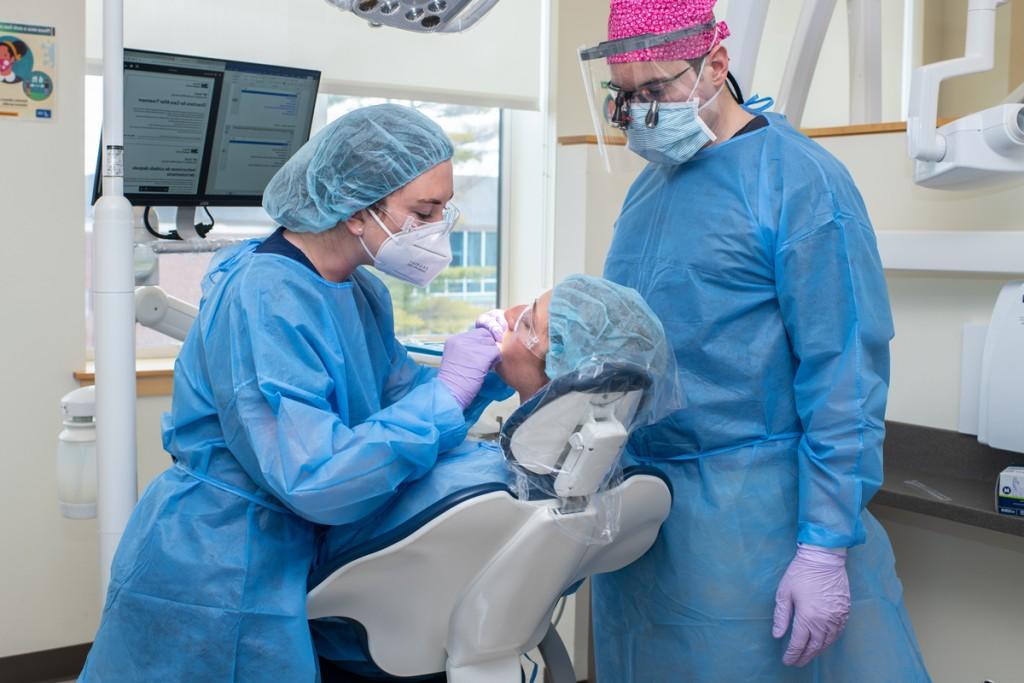 一名牙科学生和一名医师助理学生在牙科检查期间检查病人的口腔